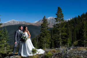 Bride and Groom pose for wedding photos at the top of Winter Park Resort